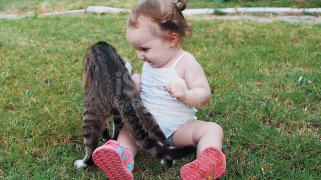 Baby playing with cat on outdoor