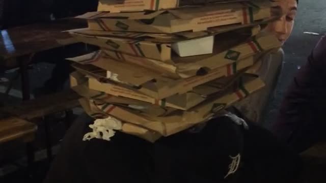 Music pizza boxes stacked up on one another in trashcan