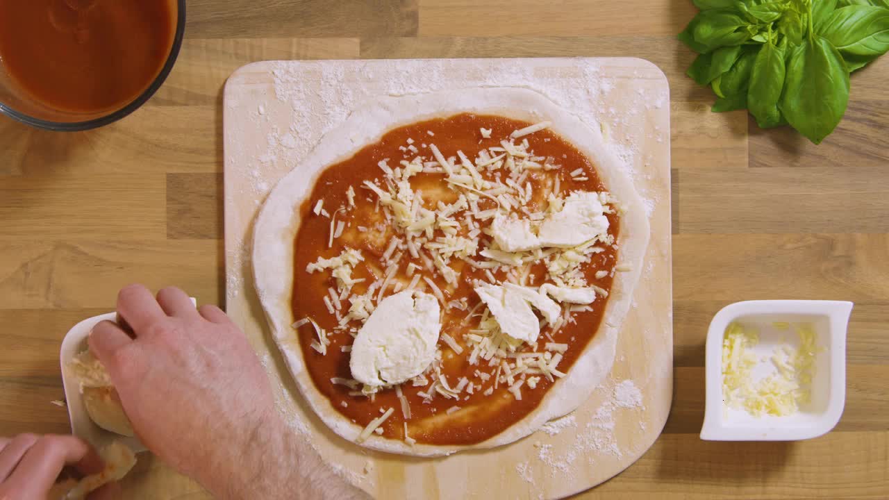 Top View Male Placing Mozzarella on Pizza