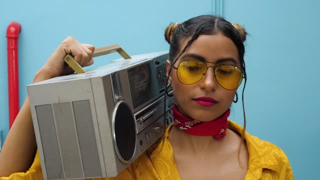 Woman carrying a retro boombox on her shoulder