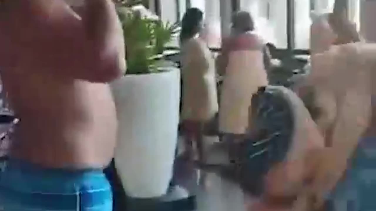 Hotel guests look on after assassins gun down man at Cancun resort