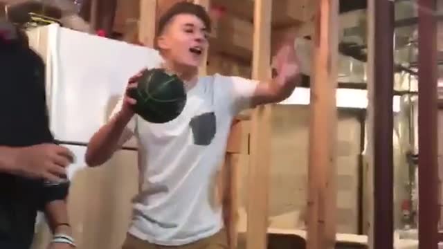 White shirt kid in basement dunks on shooting game basketball