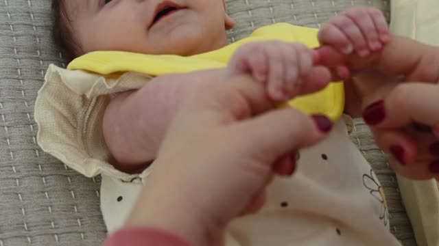 baby playing with mother