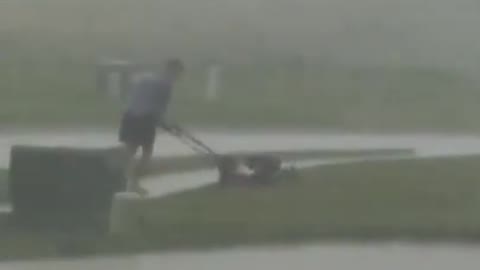 Man Goes On Mowing His Lawn In Middle of Storm