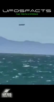 Large disc shaped object hovering above a body of water