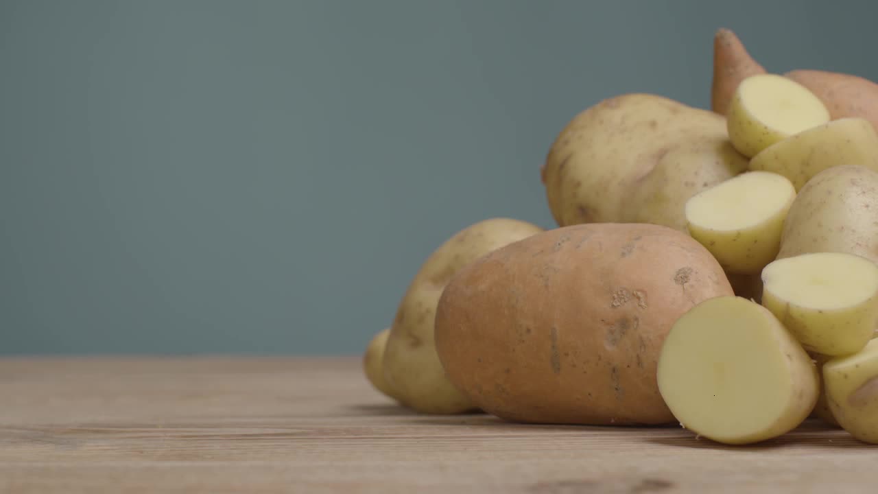 Sliding Shot Revealing Assorted Potatoes On Rustic Wooden Table 04