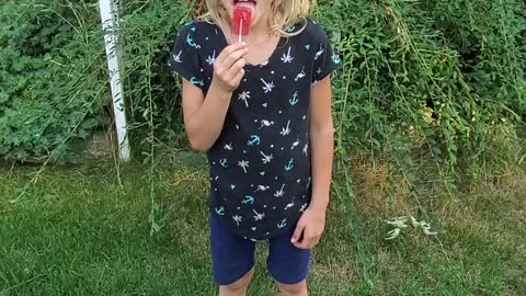 Little girl eats a cricket lollypop