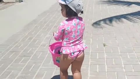 a beautiful child walking on the beach sidewalk very hot summer