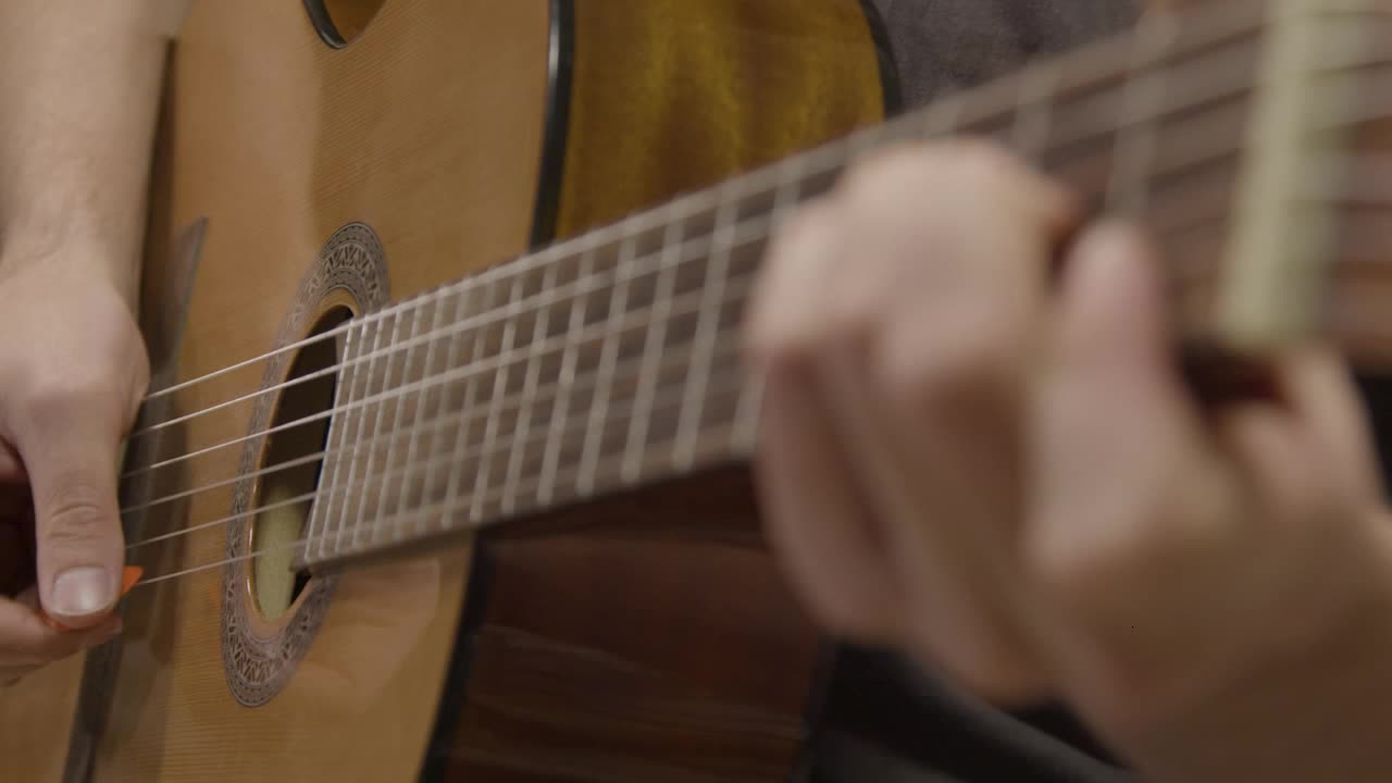 Close Up Shot of Musicians Hand On Fret Board of Acoustic Guitar