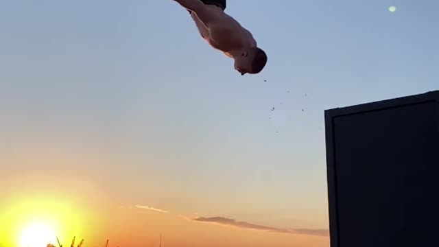 Man Performs Backflip Against Backdrop of Sunset