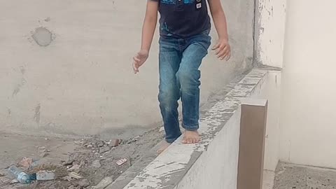 Hassan trying to walk on narrow wall