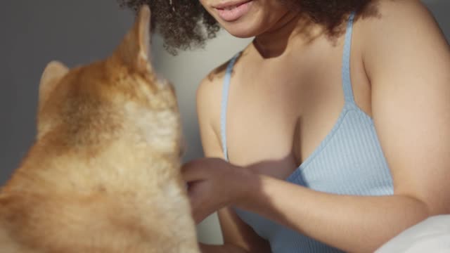 A Woman Embracing Her Pet Dog In Bed