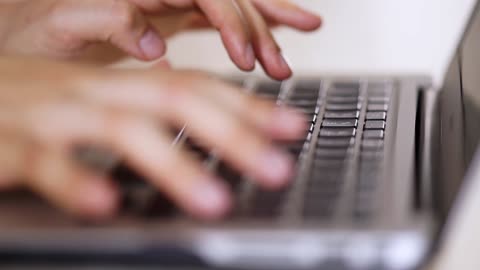 Person typing on a computer in detail