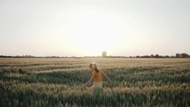 A fertile wheat field and a woman enjoying freedom