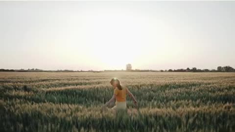 A fertile wheat field and a woman enjoying freedom