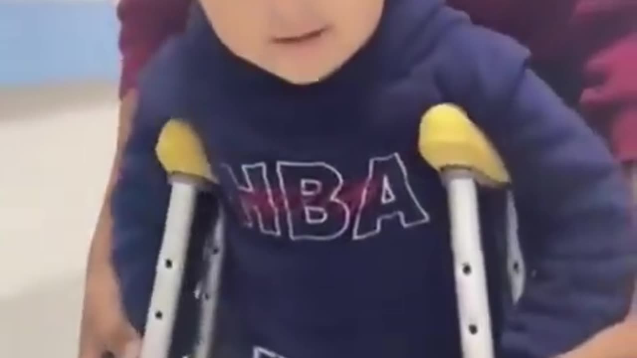 A little boy from Gaza practicing walking with crutches after losing one foot