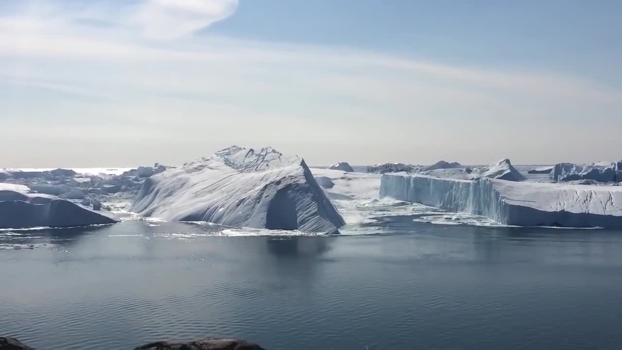 Ilulissat Icefjord - Large iceberg breaking over