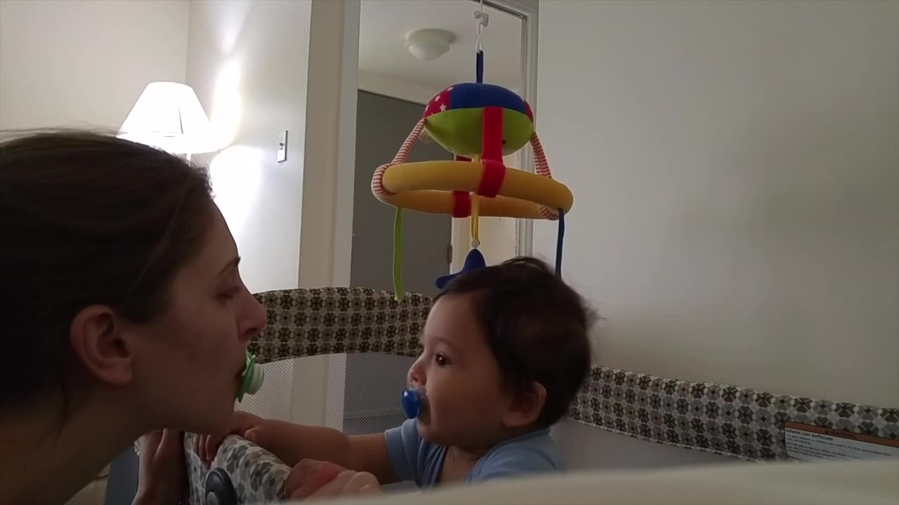 Baby exchanges pacifiers with mommy