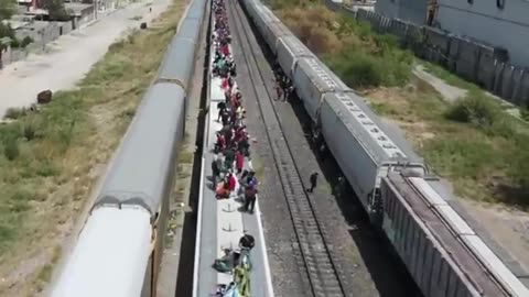 Hundreds more of migrants making their way on top of trains, some waving a Venezuelan flag, en route