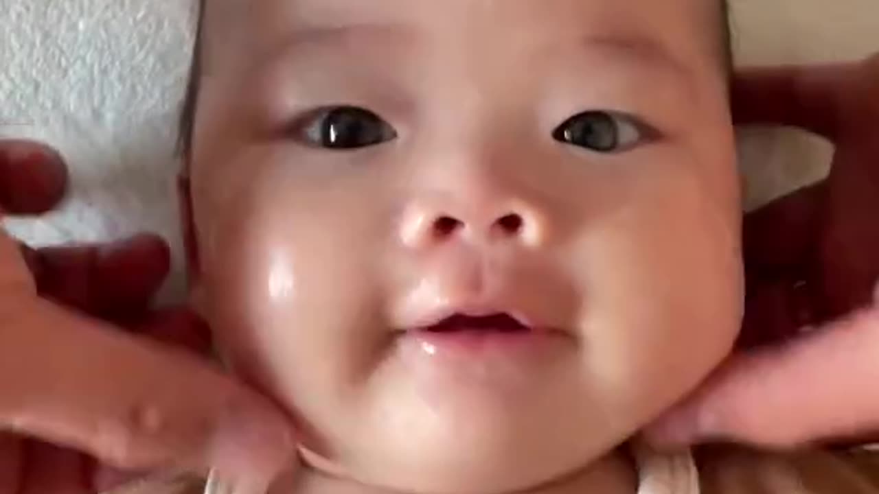 Baby face massage he's enjoying with cute smile