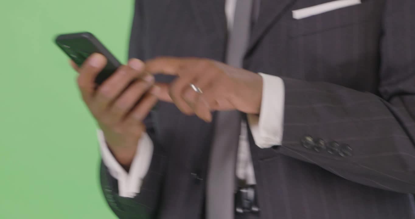 CU Businessman texting while walking on green screen