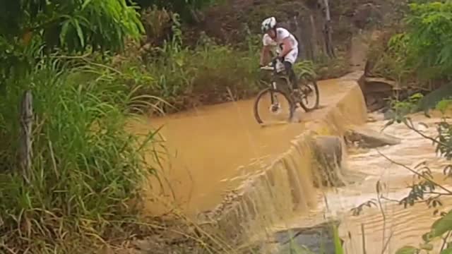 Guy on bike takes epic fall into river