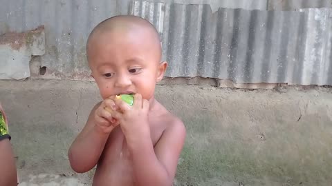 A baby boy eating mango