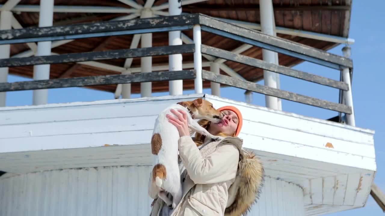 The girl with the dog on the background of the lighthouse