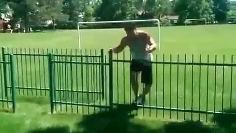 Guy jumps over metal gate and gets foot stuck on top of gate