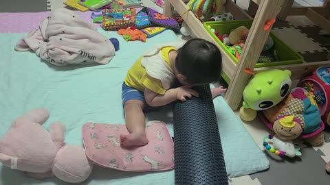 8 month old baby eating, chewing and enjoying the foam roller