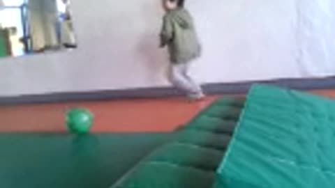 The child runs alone in the gym.