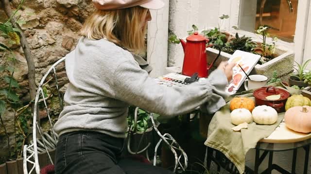 Young Woman Painting in Notebook
