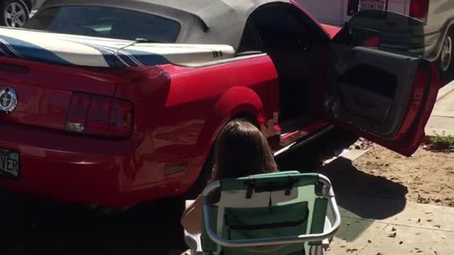 White surf board on top of red car