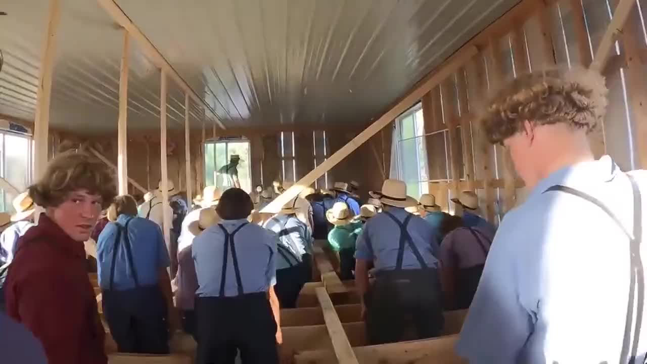 150 Amish men work together to move an abandoned building