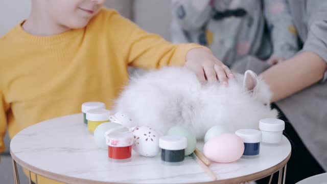 Children play with a cute fluffy rabbit