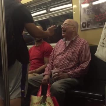 A man in red sings on train woman gets up
