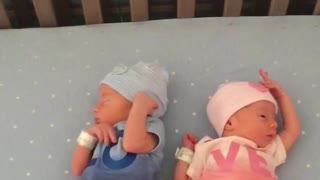 Cute newborn baby twins in sync with each other