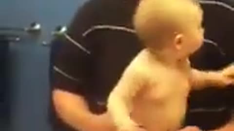 Funny baby showing off in front of mirror