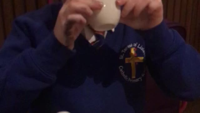 Boy in blue school uniform sweater spills drink