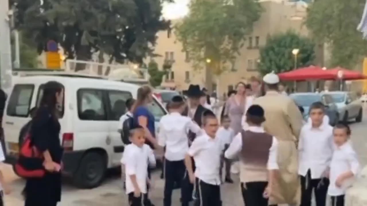 Jewish children kick, curse, and spit at a group of Christian missionaries