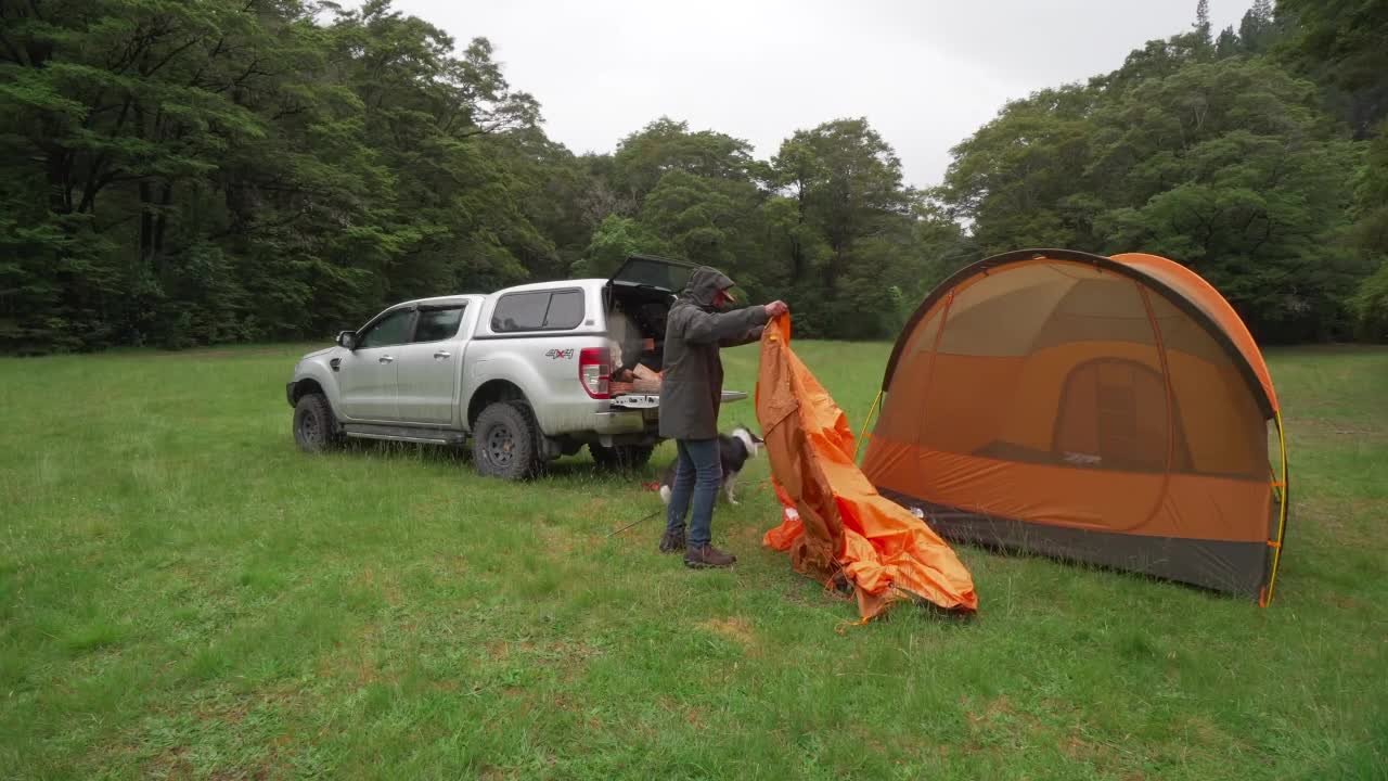 Put up a tent together, one man, one dog