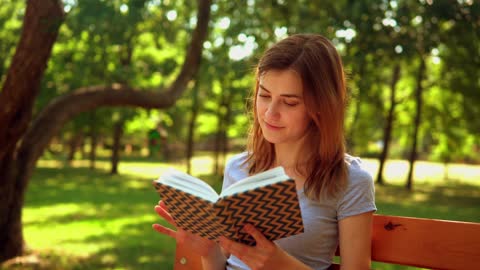 Girl reading a book in nature