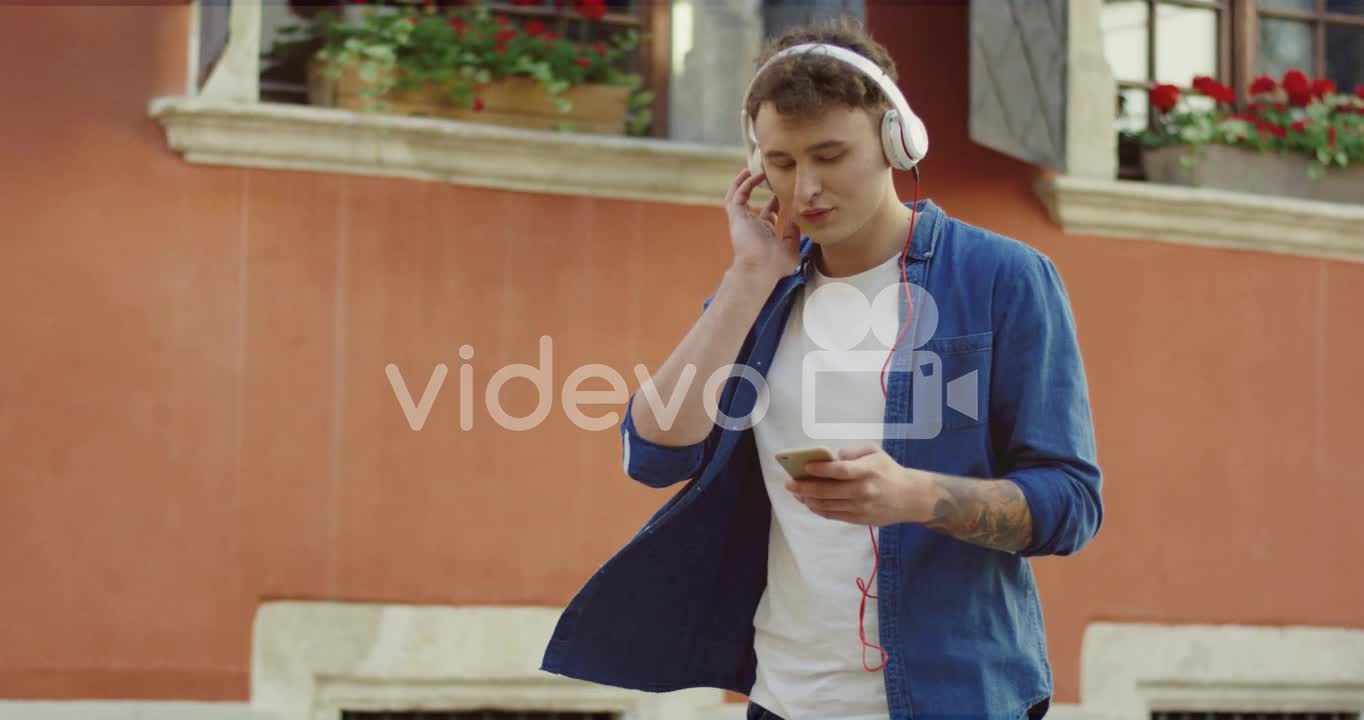 Stylish Guy Listeling To Music And Walking In The Street