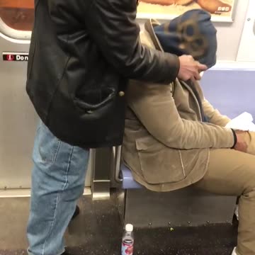 Guy graffiti tags sleeping man's head on subway train