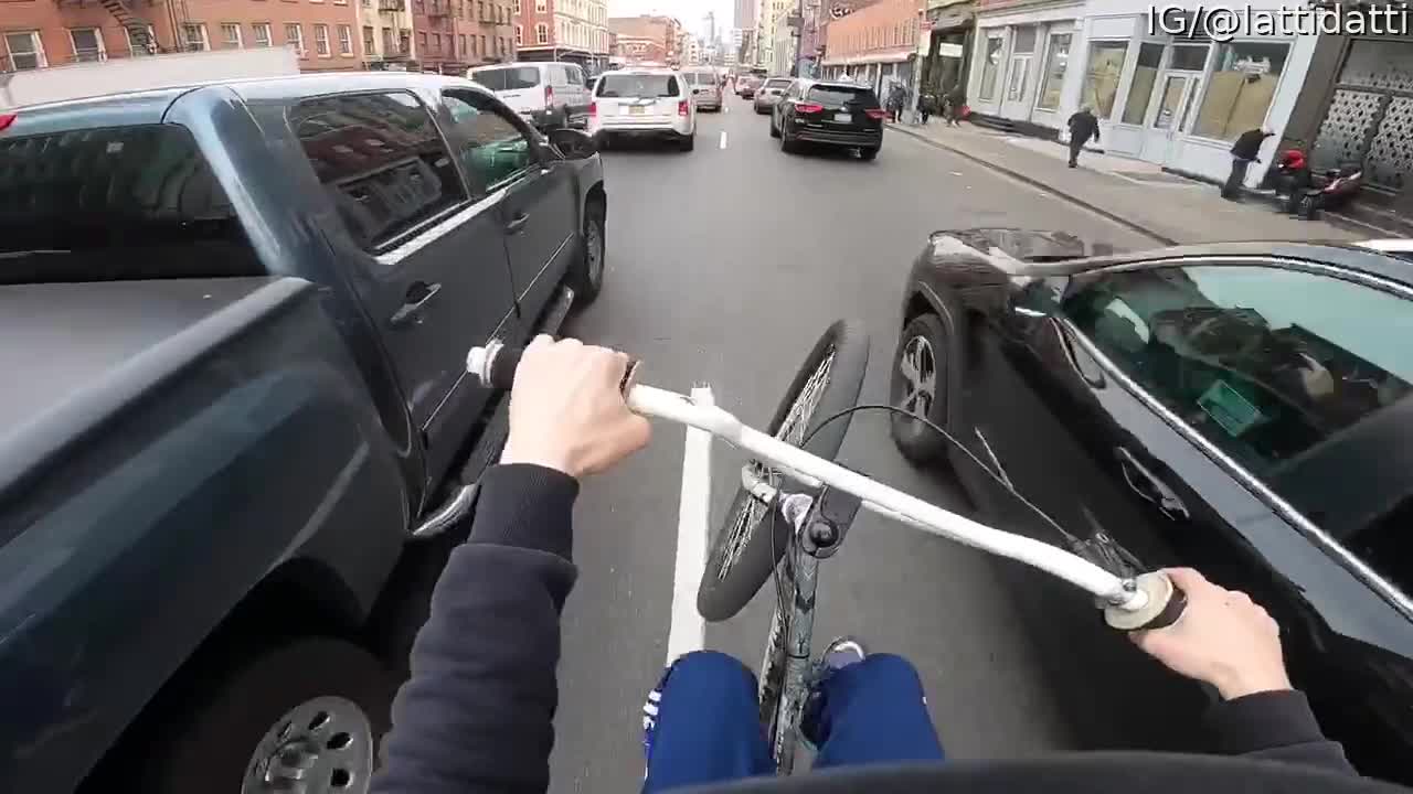 Cyclist Skillfully Weaves His Way through Traffic