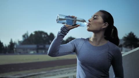 Woman drinks from water bottle