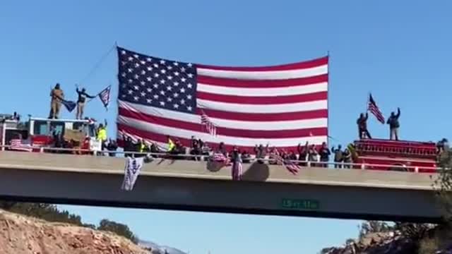 Freedom Convoy USA - People in Arizona greeting truckers with a giant US flag