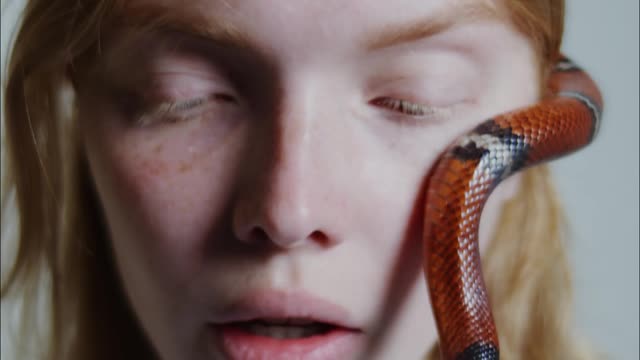 Woman Feeling Helpless On A Snake Crawling On Her Face