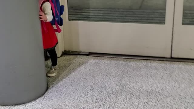 Adorable Toddler Is Playing Peek-a-boo At The Airport