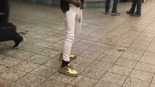 Man blonde wig white pants singing